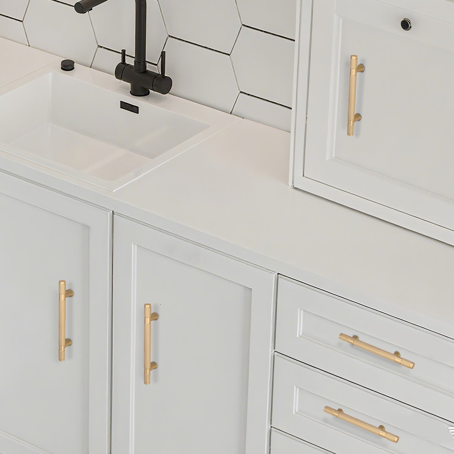 Bathroom vanity with white cabinets, gold handles, and a black faucet.
