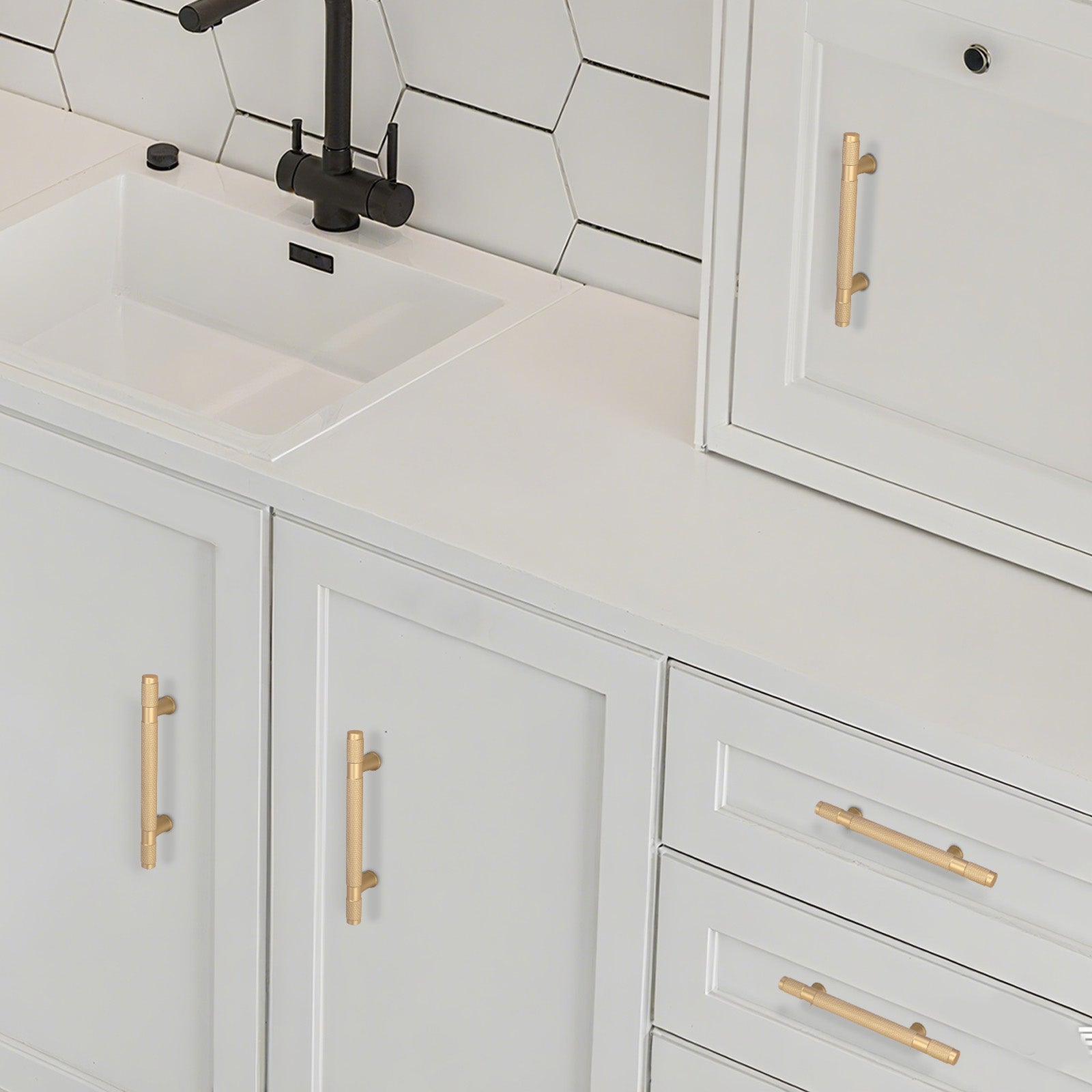 Bathroom vanity with white cabinets, gold handles, and a black faucet.