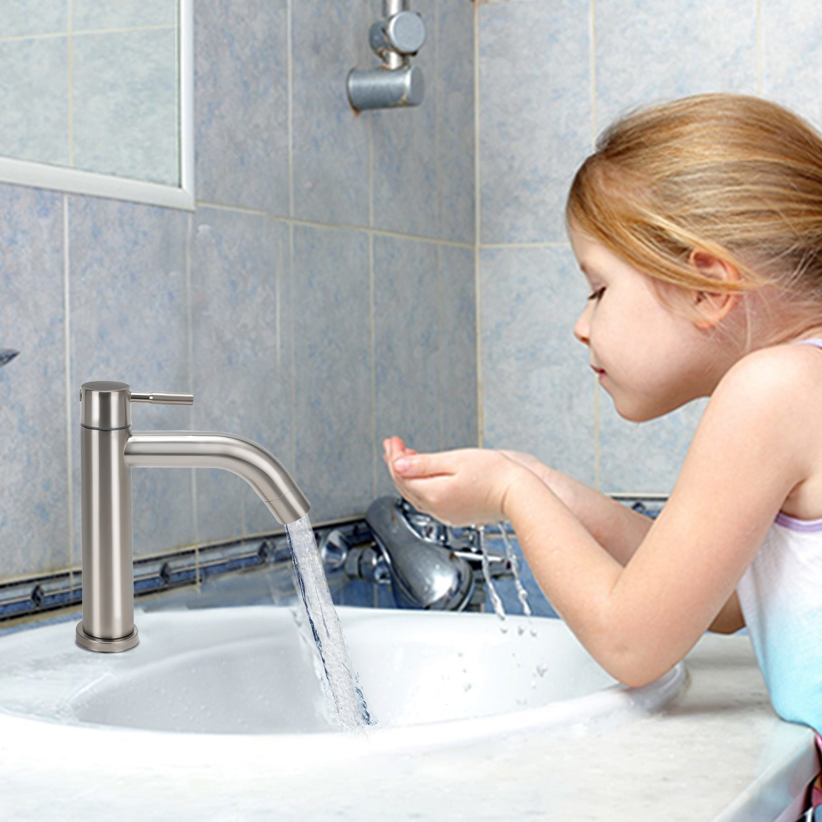 Child washing hands under a running faucet in a bathroom.
