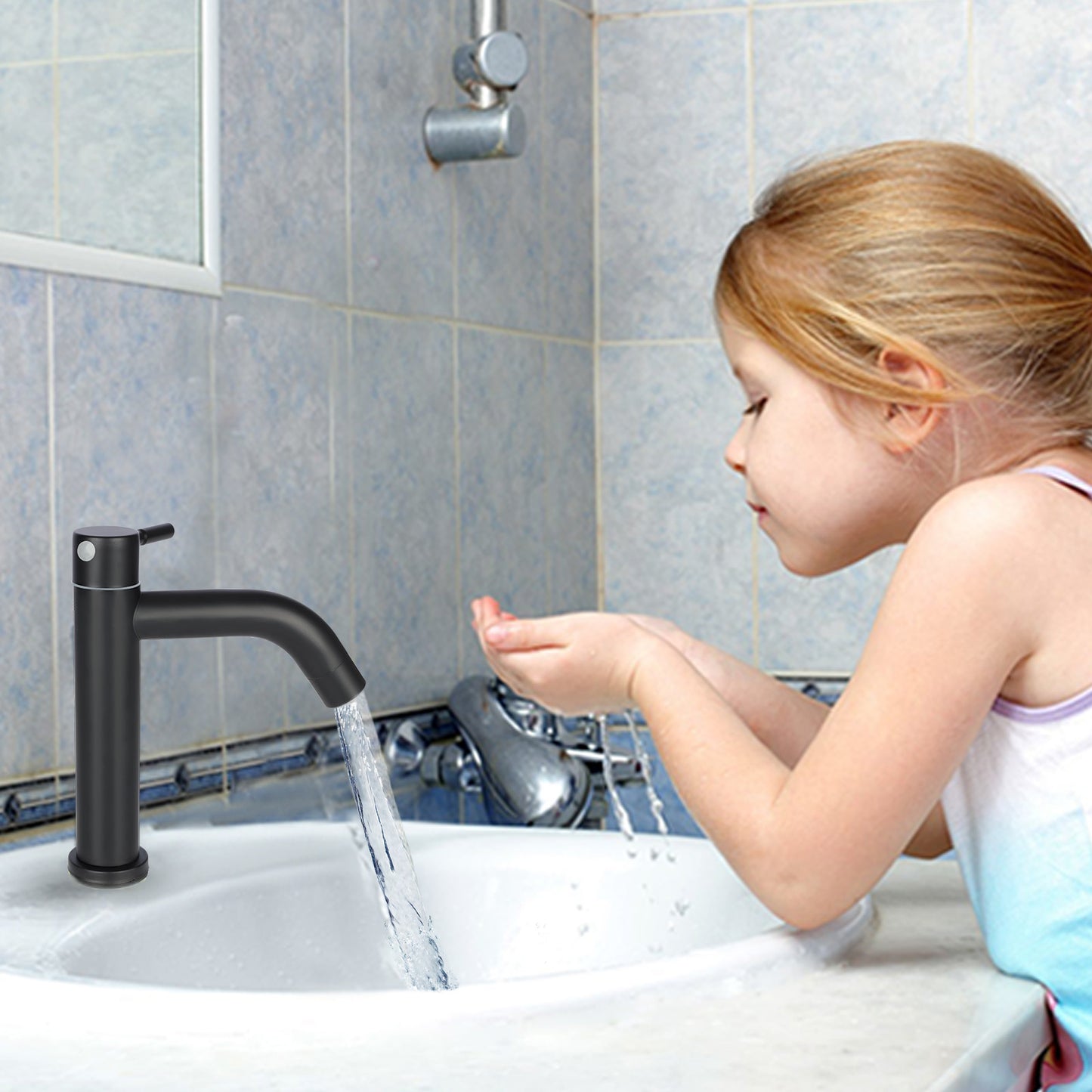 Child washing hands under a black faucet in a tiled bathroom.