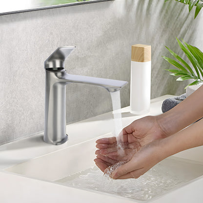 Person washing hands under a modern silver faucet in a bathroom setting.