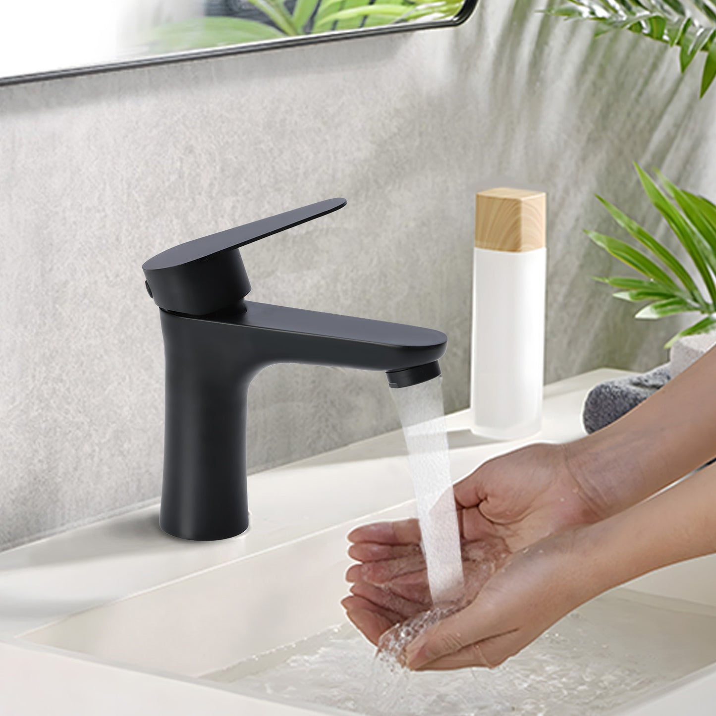 Person washing hands under a black faucet with a plant in the background