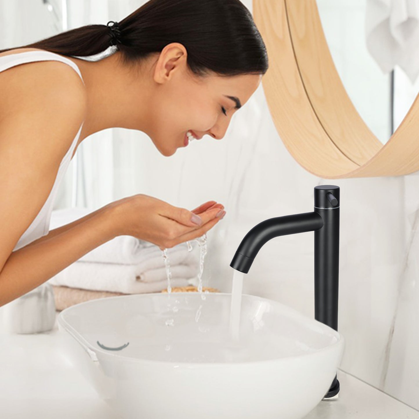 Woman washing hands under a black faucet in a bathroom setting