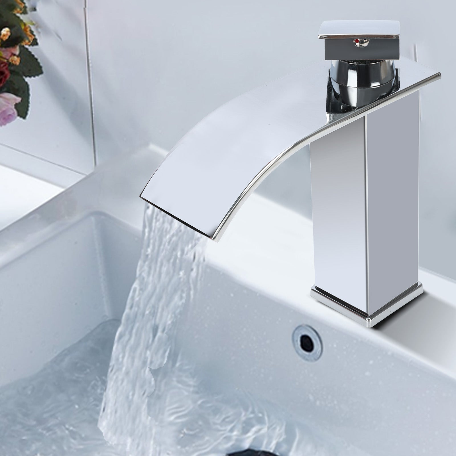 Chrome waterfall faucet with water flowing into a sink