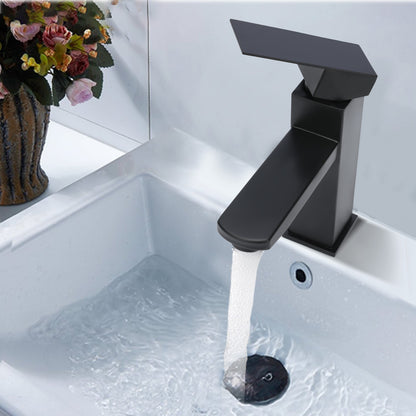 Black faucet in a sink with water flowing, next to a vase of flowers.