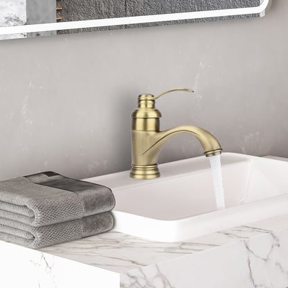 Gold faucet on a sink with gray towels and a marble countertop