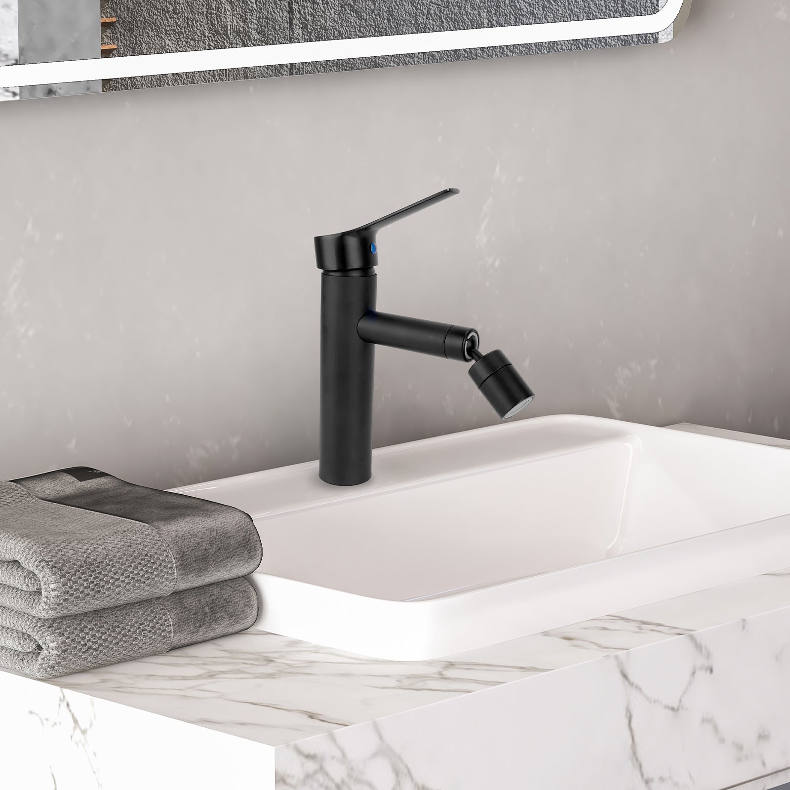 Black faucet on a marble sink with a gray towel and mirror in the background