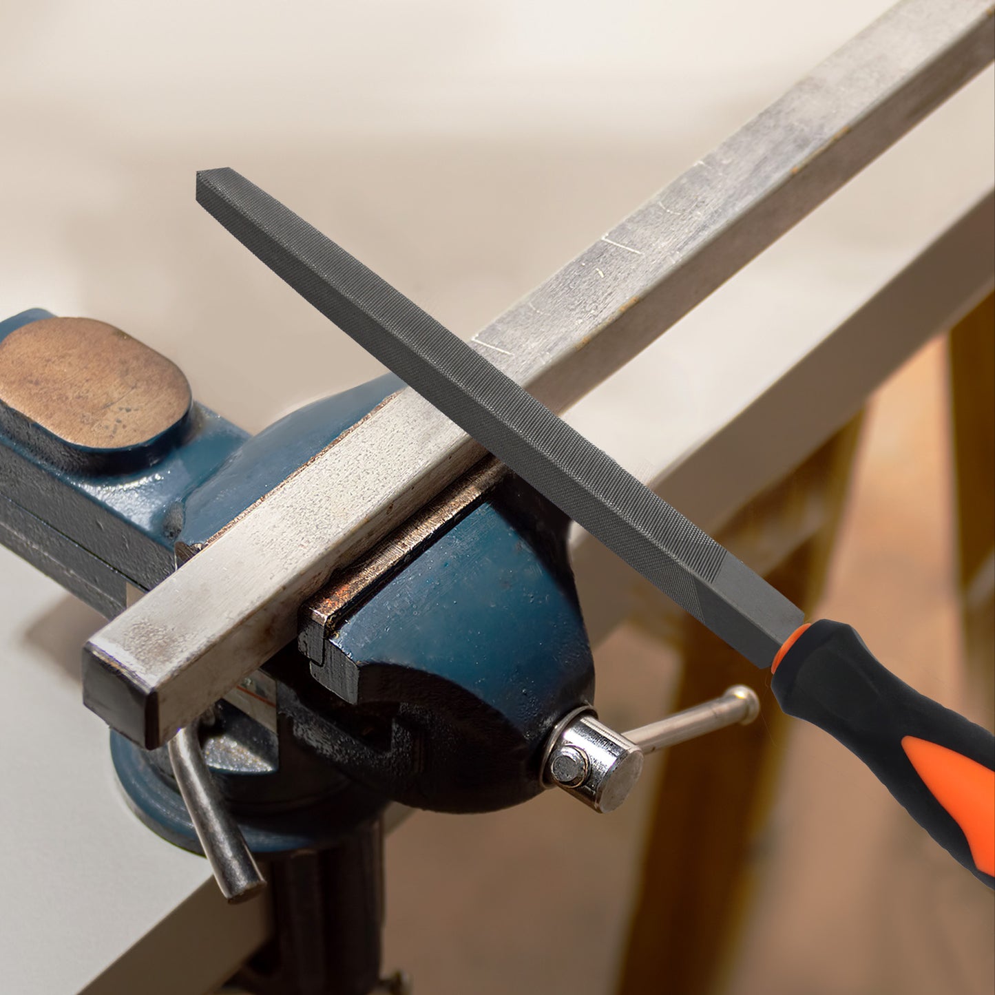 Metal file being used on a metal bar held in a vise