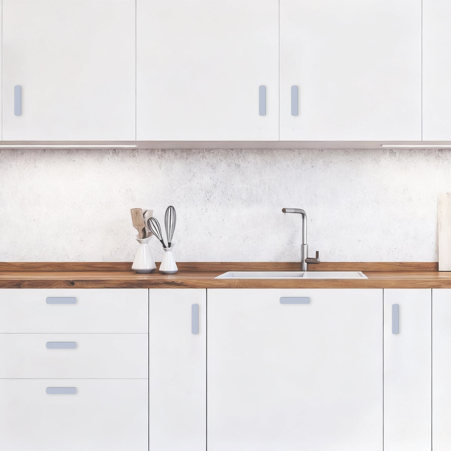 Modern kitchen with white cabinets, wooden countertop, and sink.