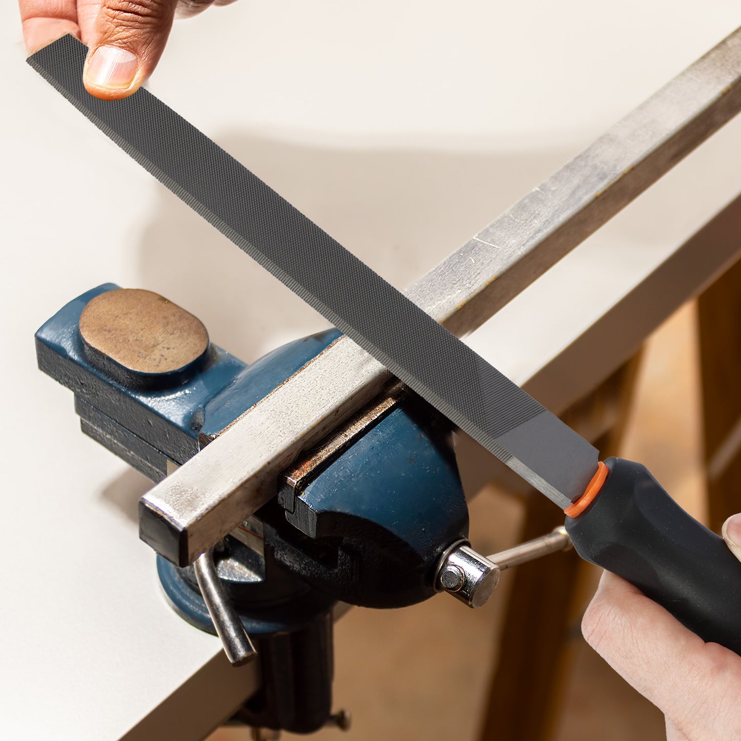 Person sharpening a knife on a stone held in a vise.