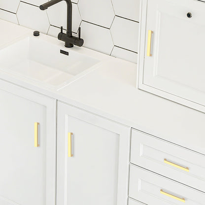 White kitchen cabinets with gold handles and a black faucet.