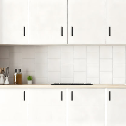 Modern kitchen with white cabinets, tiled backsplash, and countertop.