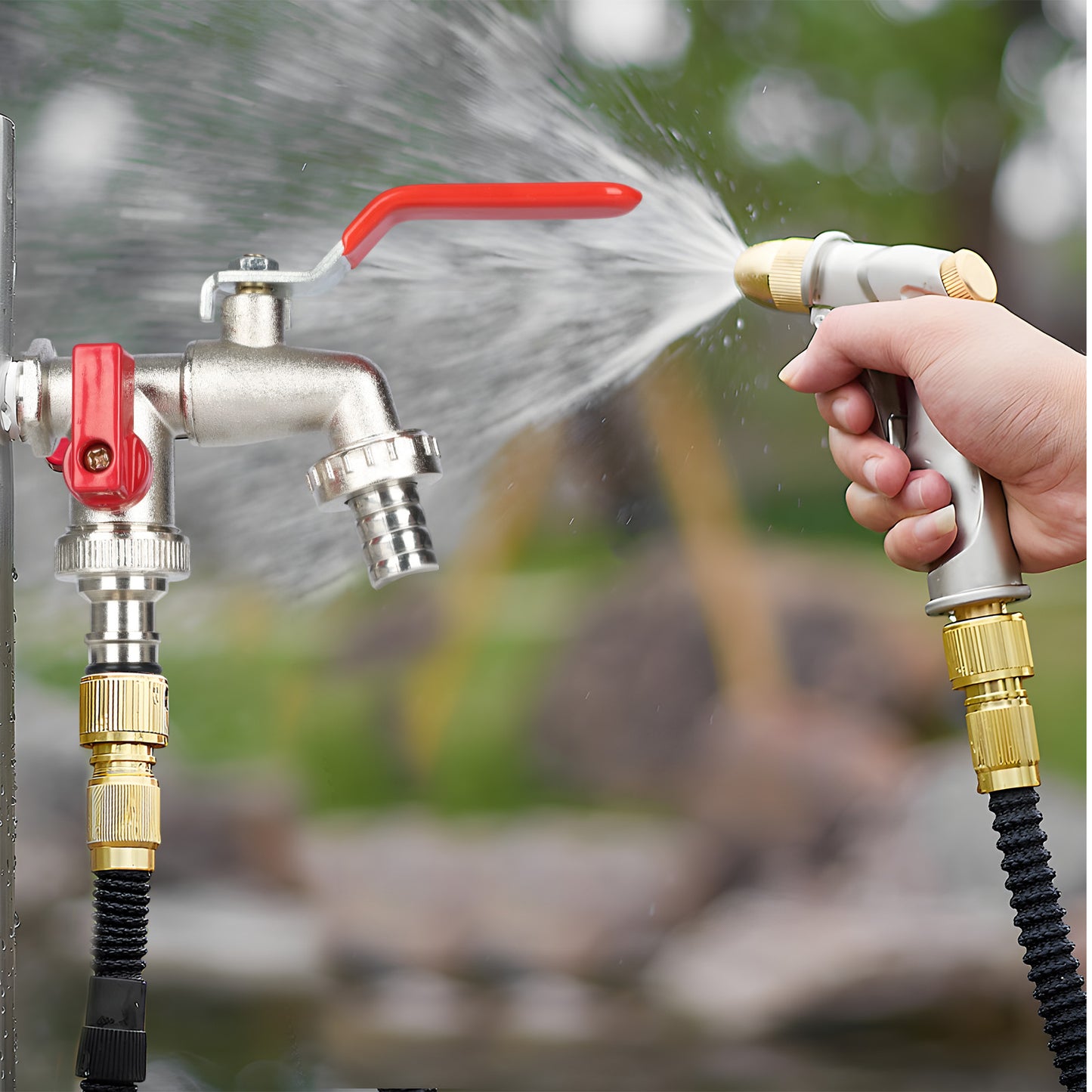 Hand holding a garden hose sprayer with water flowing from a faucet