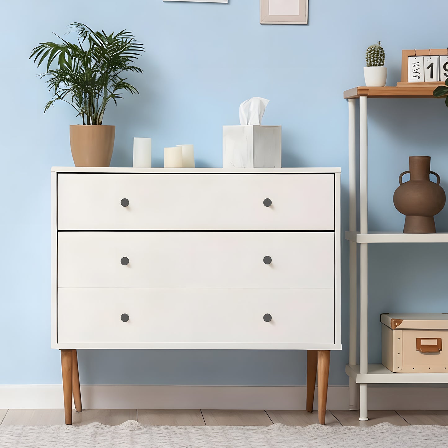 White dresser with wooden legs against a light blue wall with decorative items.