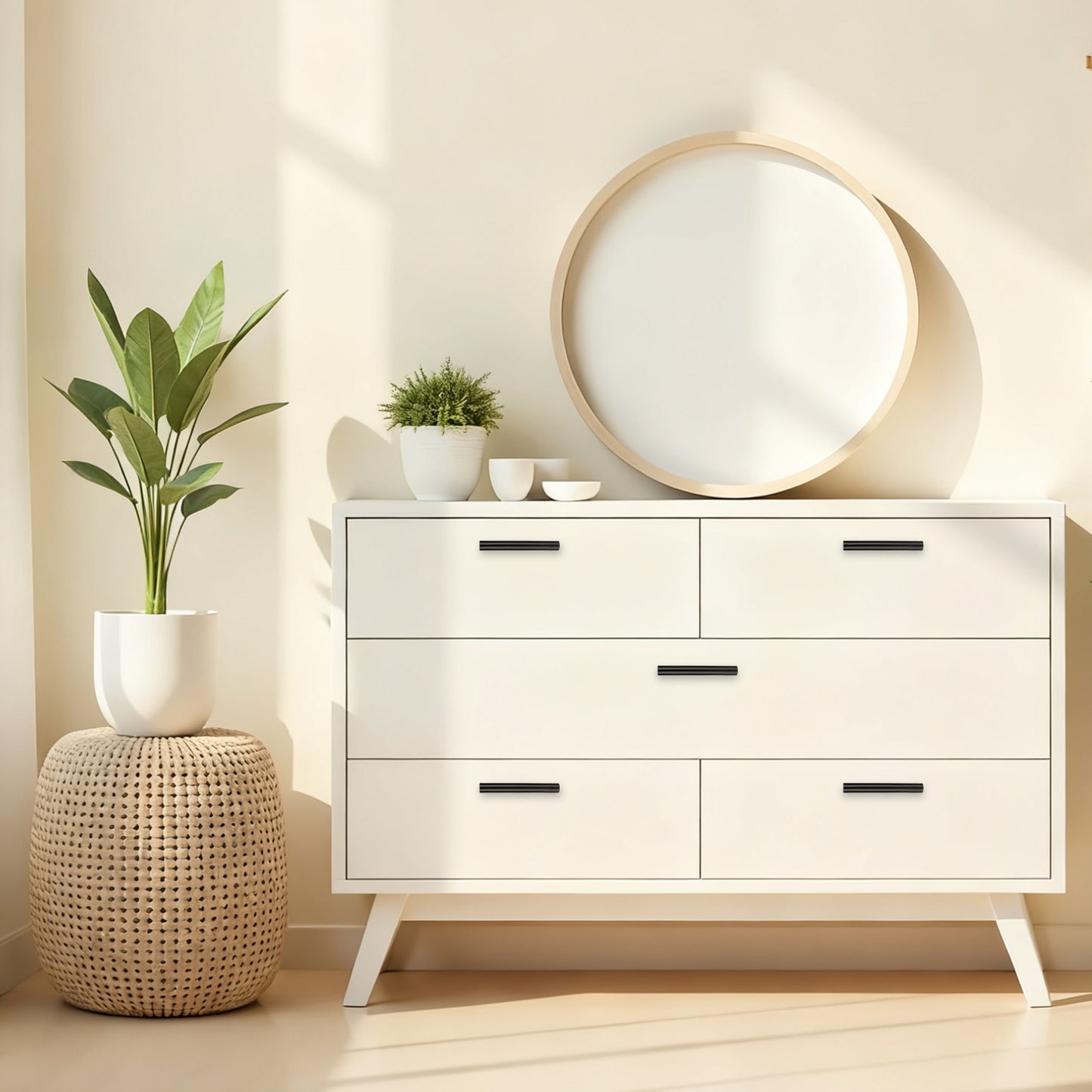 White dresser with four drawers, round mirror, and plants in a room with a neutral color scheme.