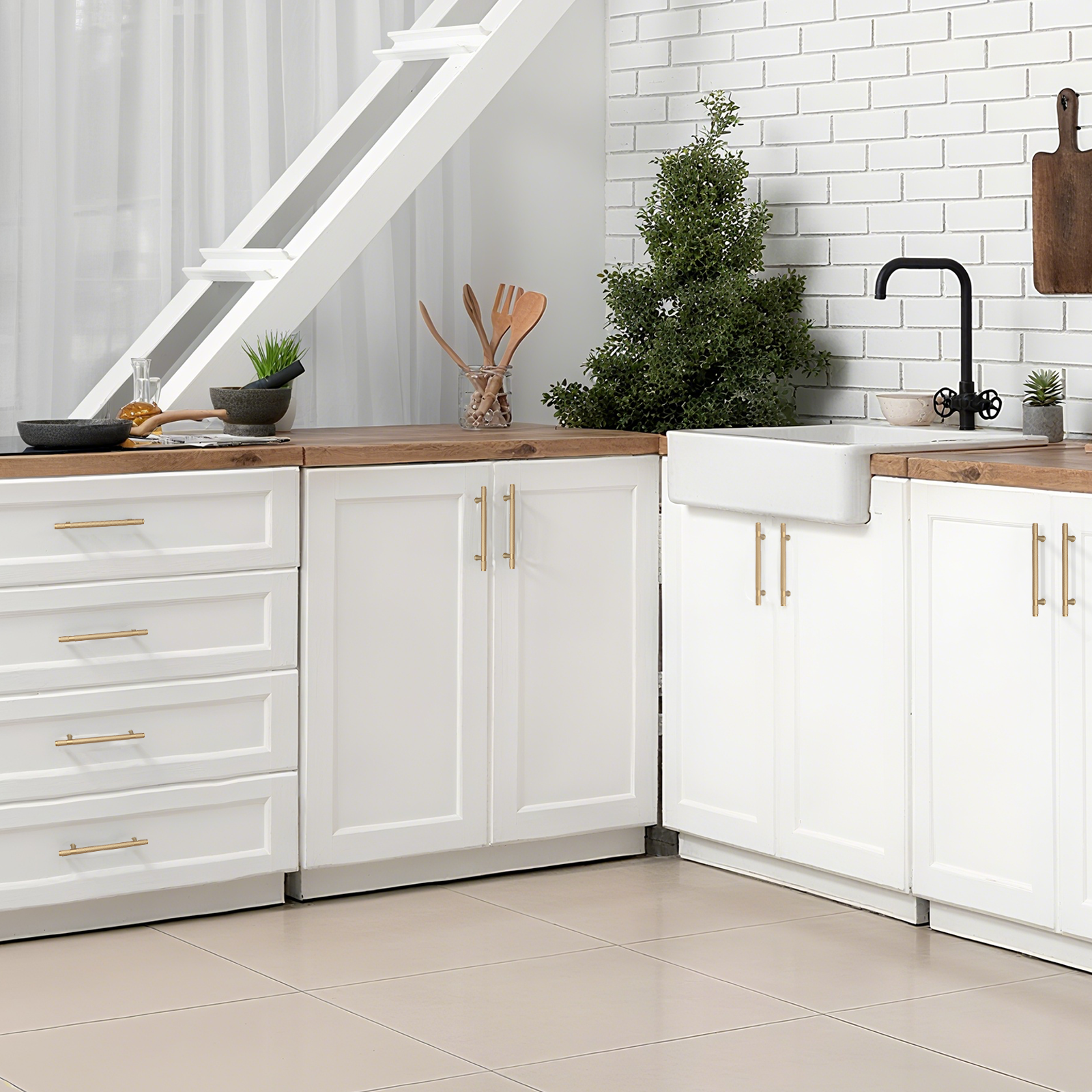 Modern kitchen with white cabinets, wooden countertops, and a small Christmas tree.