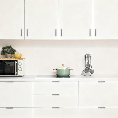Modern kitchen with white cabinets, a green pot on the stove, and various kitchen items.