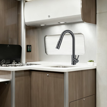 Modern kitchen interior with a sink, faucet, and wooden cabinets.