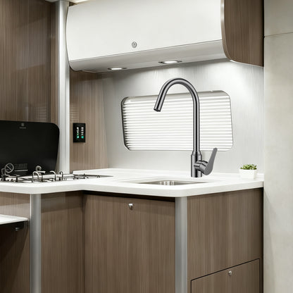 Modern kitchen interior with a sink, faucet, and wooden cabinets.