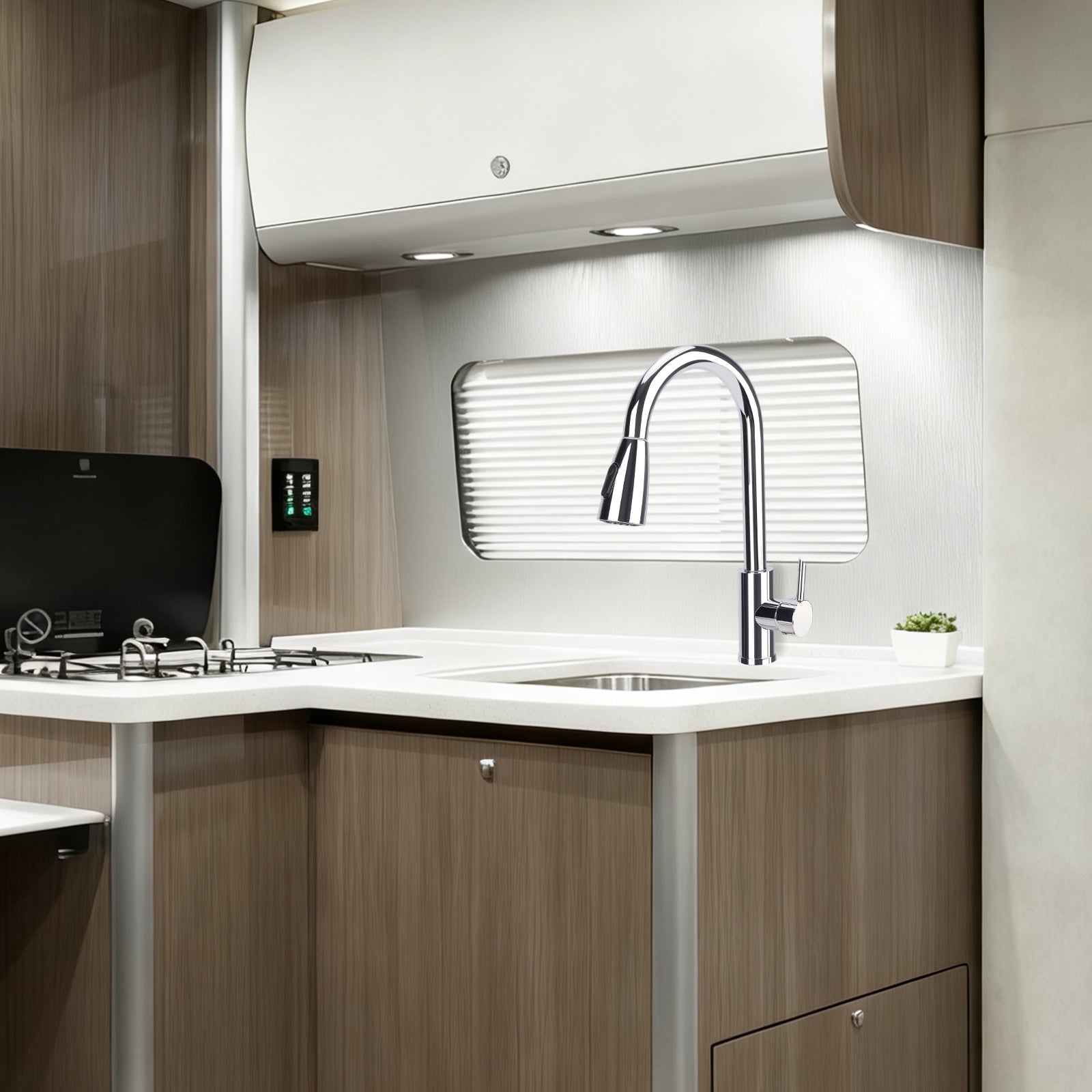 Modern kitchen interior with a sink, faucet, and wooden cabinets.