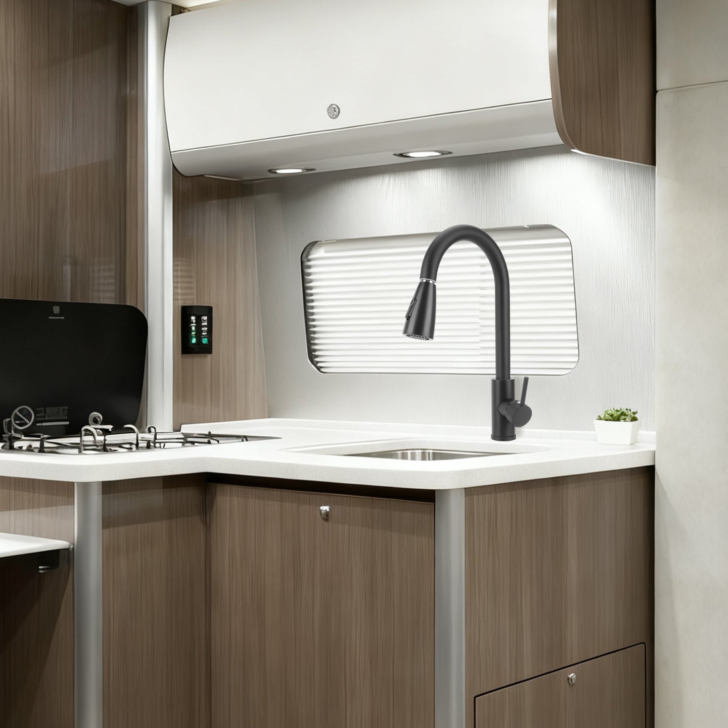 Modern kitchenette with sink, faucet, and stove in a compact space.