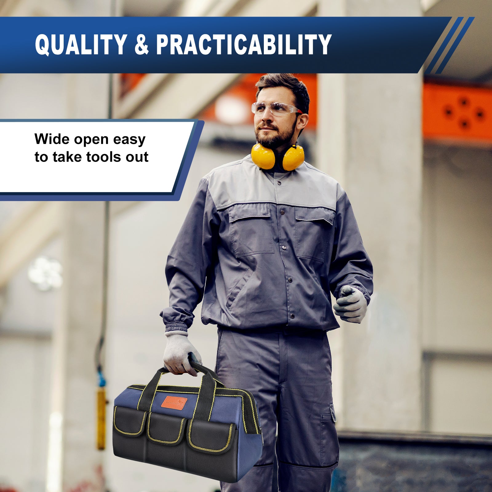 A man in a gray work uniform and safety glasses stands in an industrial setting, holding a blue and gray tool bag with yellow piping. He has yellow ear muffs around his neck.