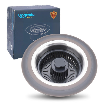A round kitchen sink drain strainer basket with a gray outer ring and black center, shown in front of its blue Upgrade NEW 2.0 product box on a white background.